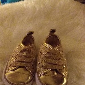 Gold and white tennis shoe with gold gittler